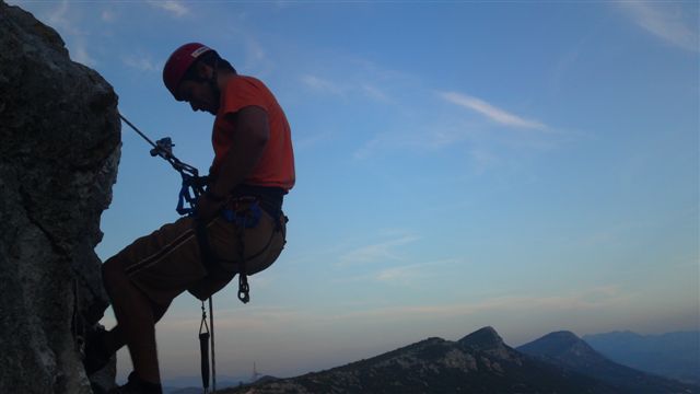 Marin Banović Bane, predsjednik SPK Kaštela poznatog i kao Kaštelanska škola dinamike, u abseilu niz Malačku. Greben Kozjaka koji se vidi u daljini je njegova rodna gruda!